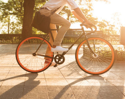 Half body shot of a male cyclist riding his bicycle at sunset.
